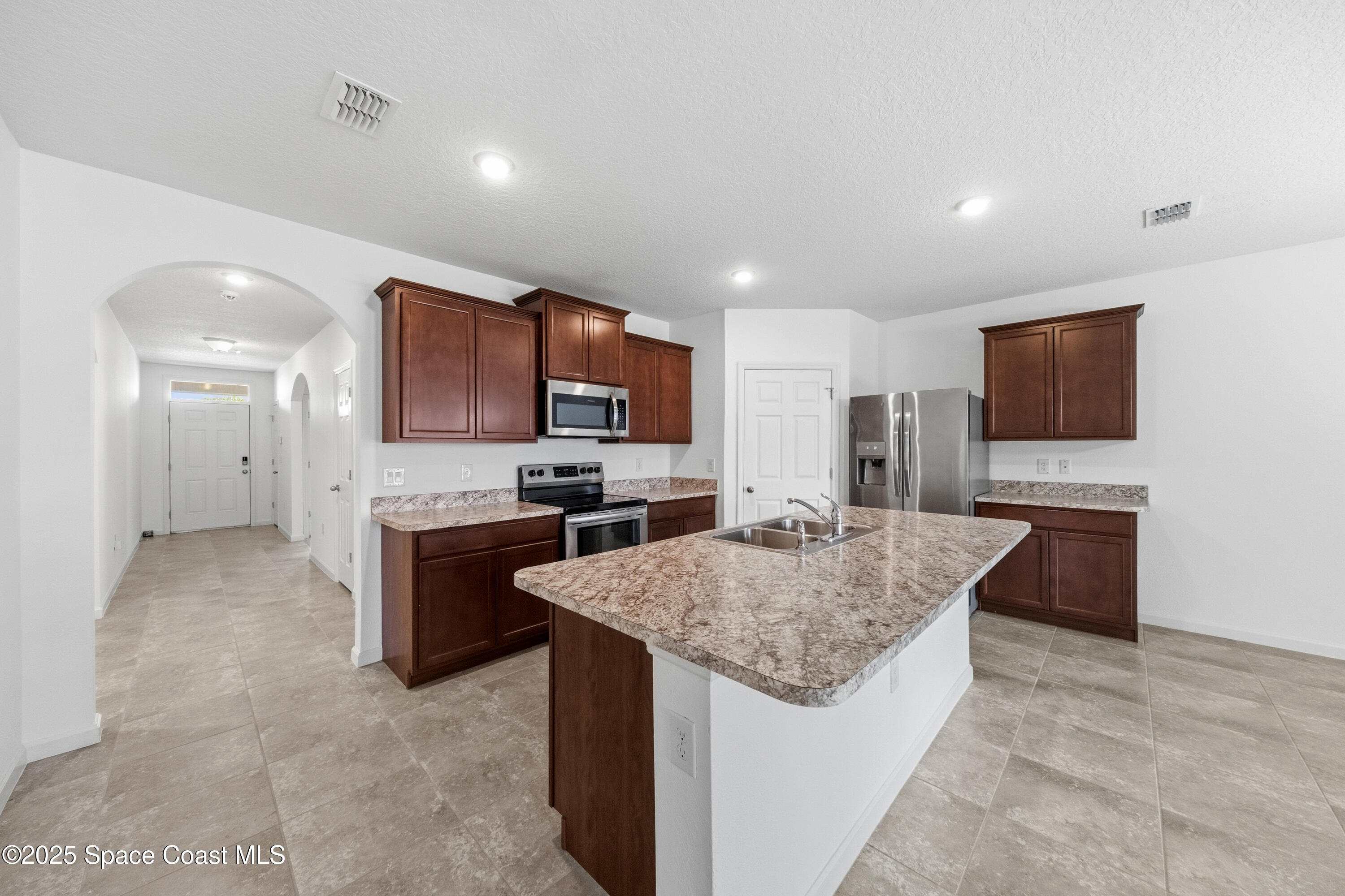 377 Snook Place Cocoa, FL 32927 - Photo 7 of 32 a kitchen with granite countertop a sink and steel appliances