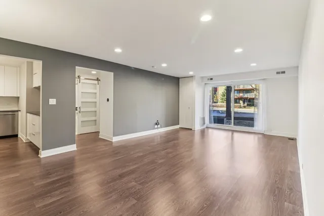 a view of an empty room with wooden floor