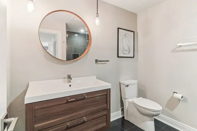 a white toilet sitting next to a bathroom sink