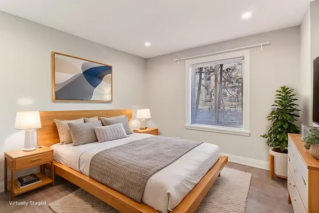 an empty room with wooden floor closet and windows