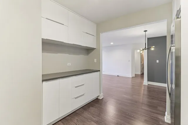a view of a kitchen with wooden floor electronic appliances and wooden floor