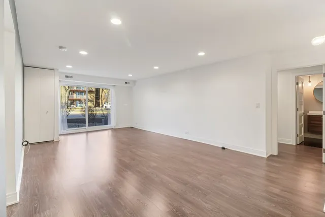 a living room with furniture potted plant and a wooden floor