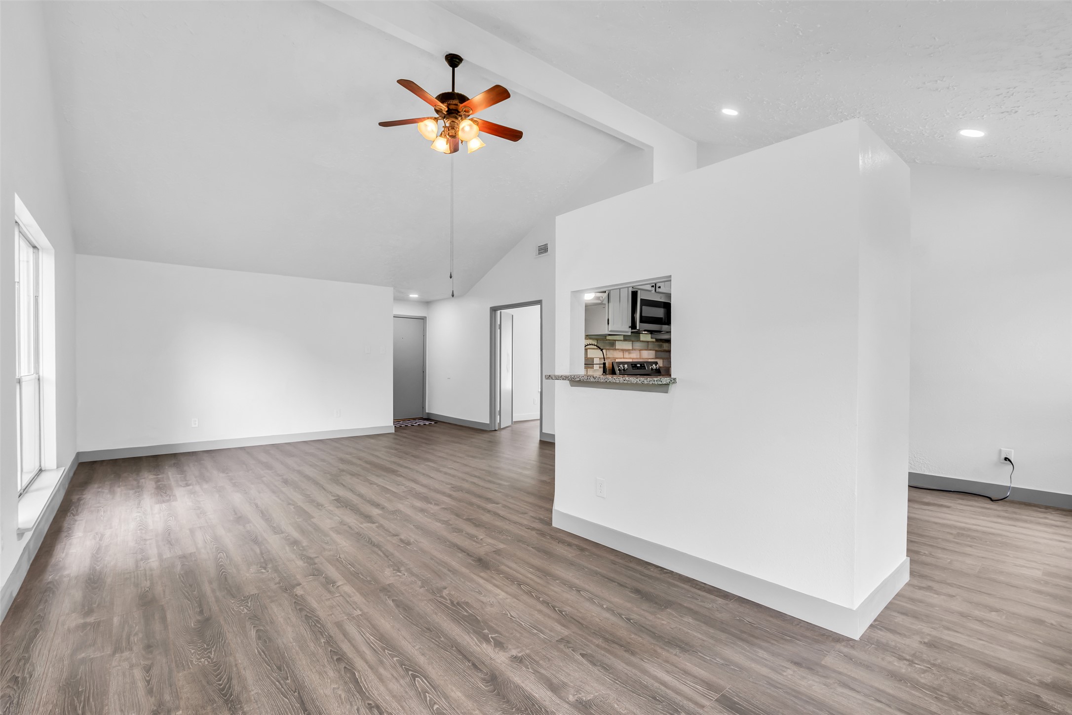 4631 Enchanted Rock Lane Spring, TX 77388 - Photo 5 of 12 Vast main living area with vaulted ceilings and durable wood-look flooring.