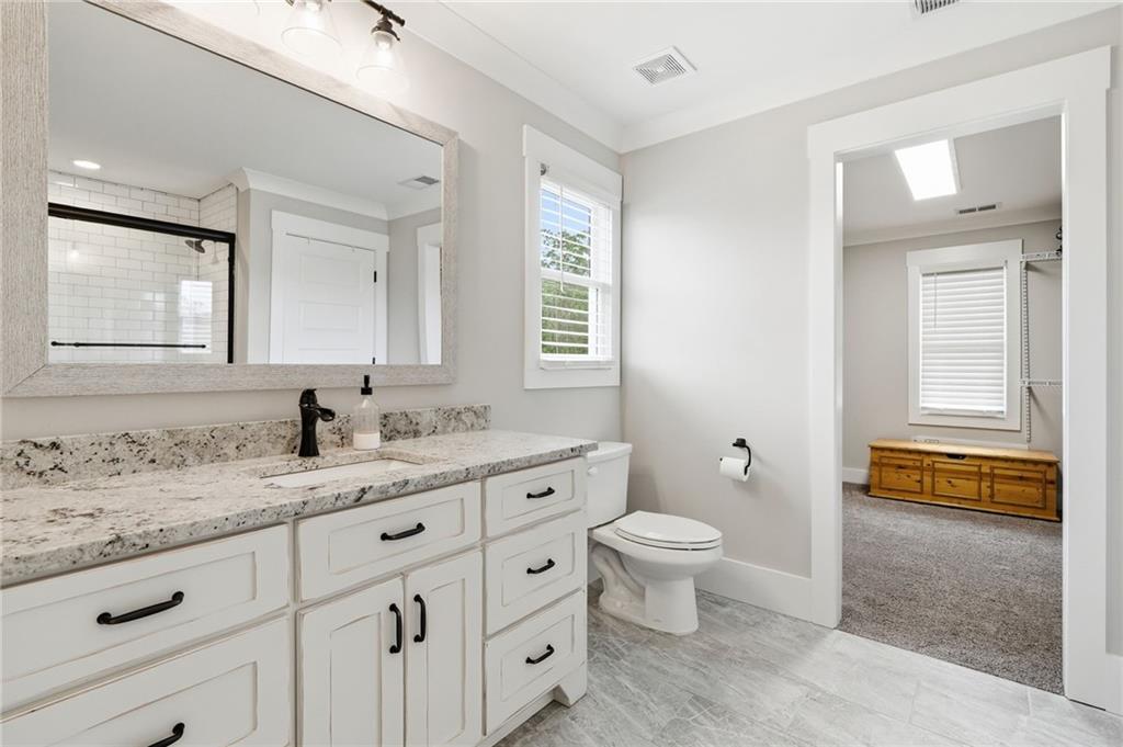 180 Laurel Ridge Lane Ball Ground, GA 30107 - Photo 34 of 71 a bathroom with a granite countertop toilet sink and mirror