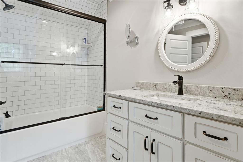 180 Laurel Ridge Lane Ball Ground, GA 30107 - Photo 40 of 71 a bathroom with a granite countertop sink a mirror and shower