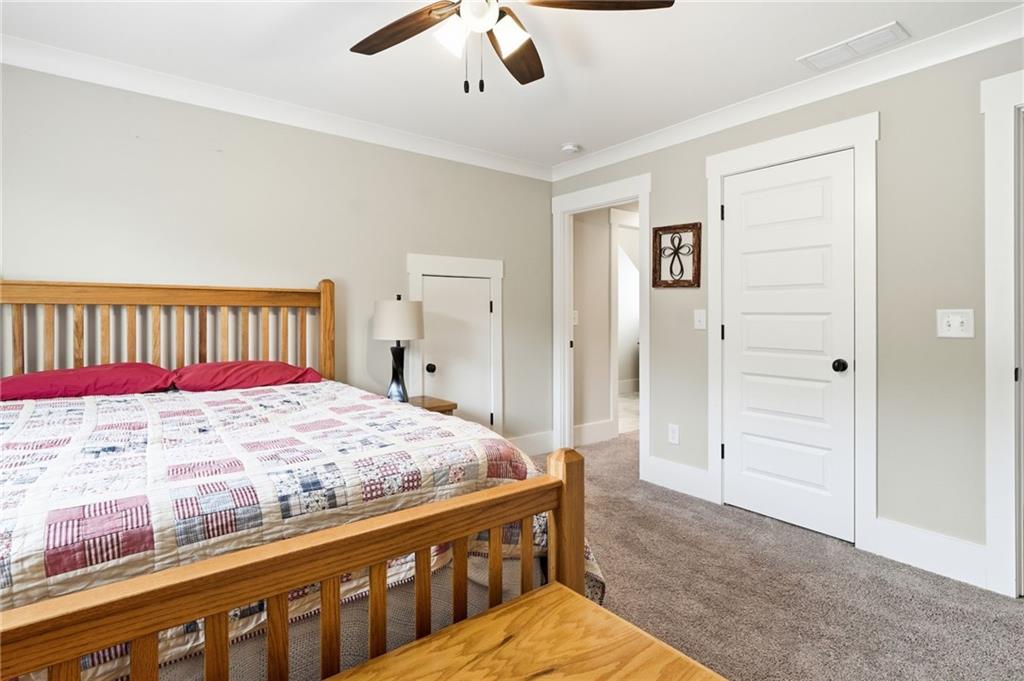 180 Laurel Ridge Lane Ball Ground, GA 30107 - Photo 42 of 71 a bedroom with a bed and a chandelier