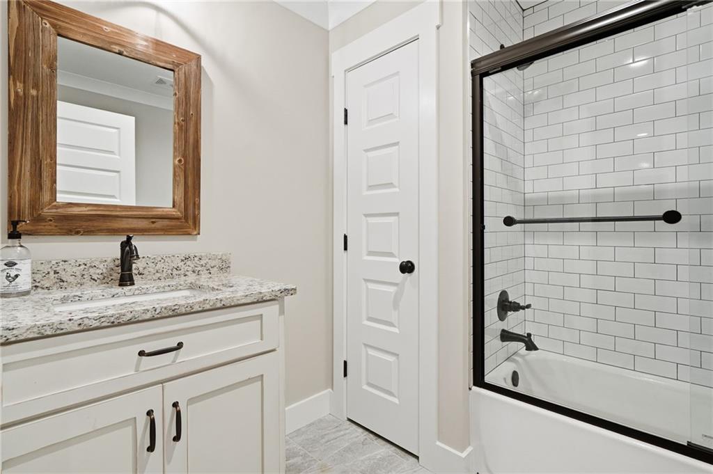 180 Laurel Ridge Lane Ball Ground, GA 30107 - Photo 46 of 71 a bathroom with a granite countertop sink a toilet and shower