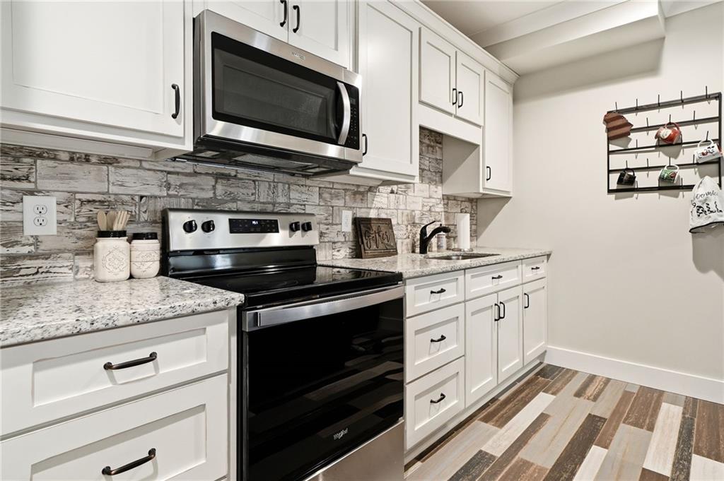 180 Laurel Ridge Lane Ball Ground, GA 30107 - Photo 48 of 71 a kitchen with stainless steel appliances granite countertop white cabinets and white appliances