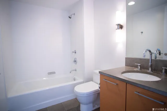 a bathroom with a sink toilet mirror vanity and bathtub