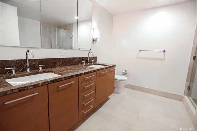 a bathroom with a granite countertop sink a toilet and a mirror