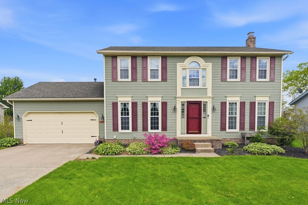 5321 Young Road Stow, OH 44224 - Photo 1 of 37 Two-story colonial residence featuring light green siding, contrasting red shutters, and a prominent red front door