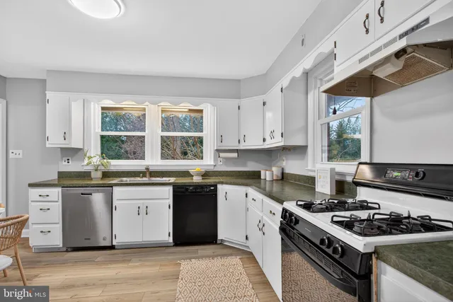 a kitchen with a stove a sink and a window