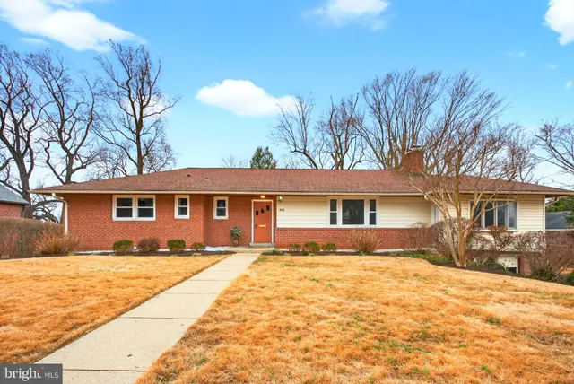 a front view of a house with a yard covered with snow