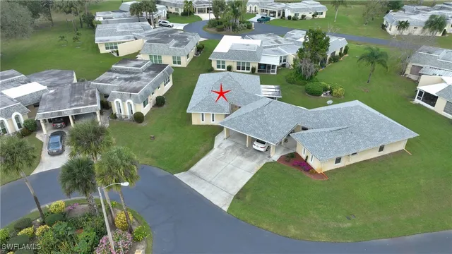an aerial view of residential houses with outdoor space and trees