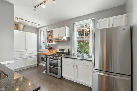 a kitchen with stainless steel appliances a refrigerator sink and cabinets