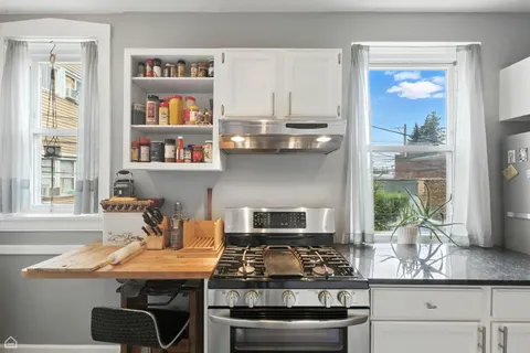 a kitchen with stainless steel appliances kitchen island granite countertop a stove a chimney and a counter space