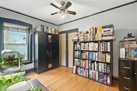 a living room with furniture a bookshelf and a window