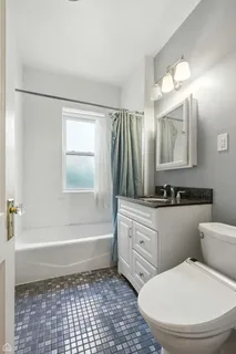 a bathroom with a sink a toilet a mirror a vanity and bathtub