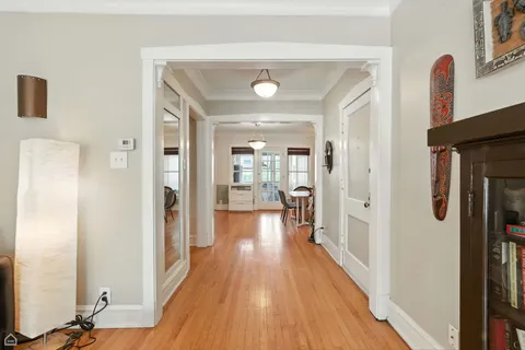 a view of a hallway with wooden floor and closet area