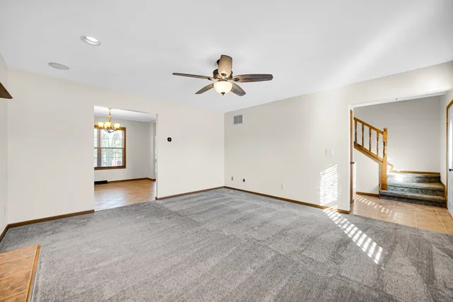 a view of n empty room with window and a ceiling fan