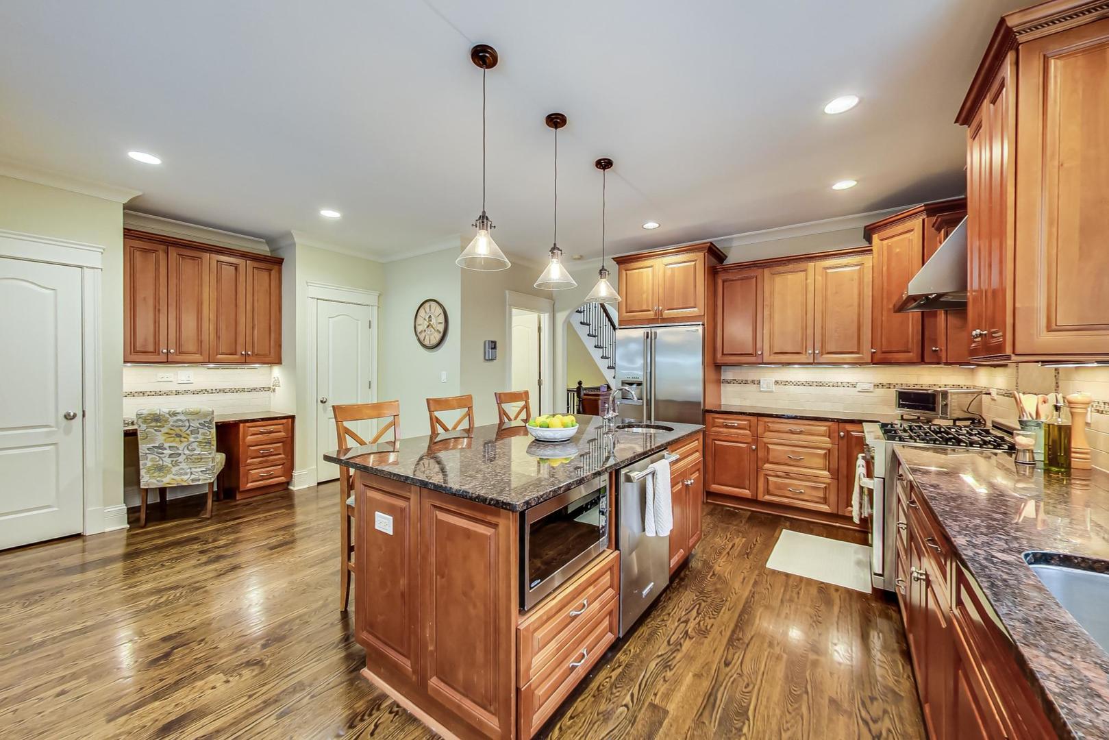 335 Ridge Road Kenilworth, IL 60043 - Photo 6 of 26 a kitchen with stainless steel appliances granite countertop wooden cabinets a stove top oven a sink and dishwasher