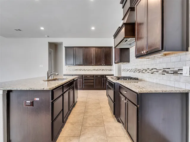 a kitchen with stainless steel appliances granite countertop a sink stove and cabinets