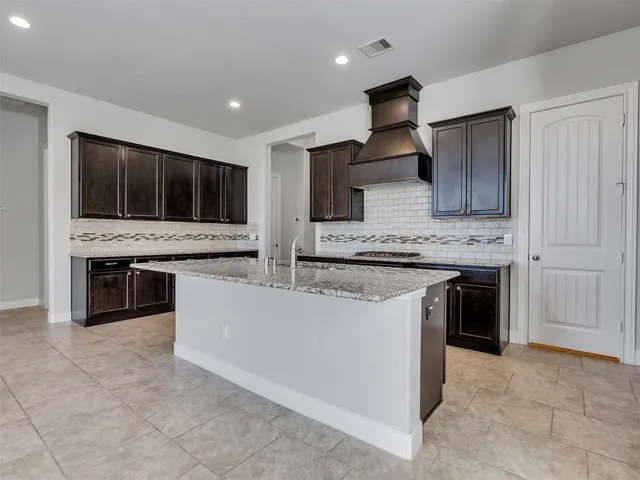a large kitchen with stainless steel appliances granite countertop a stove and a sink