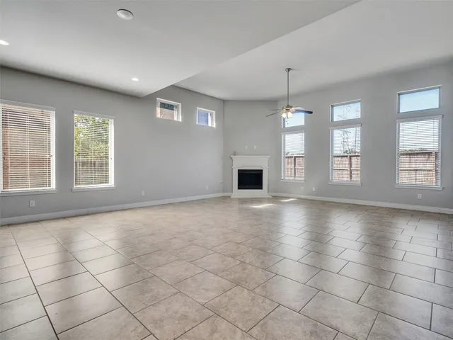 an empty room with windows and fireplace