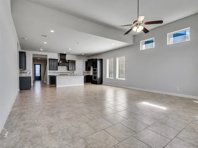 a view of a livingroom with furniture a ceiling fan and window