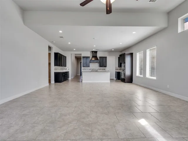 a view of empty room with a kitchen