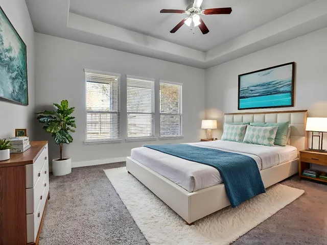 a spacious bedroom with a large bed and a chandelier