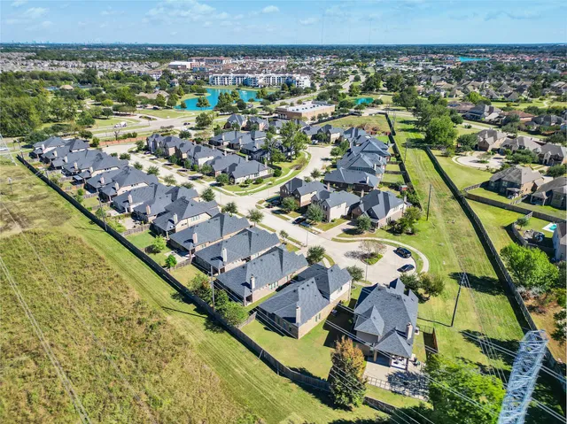 an aerial view of residential houses with outdoor space and swimming pool