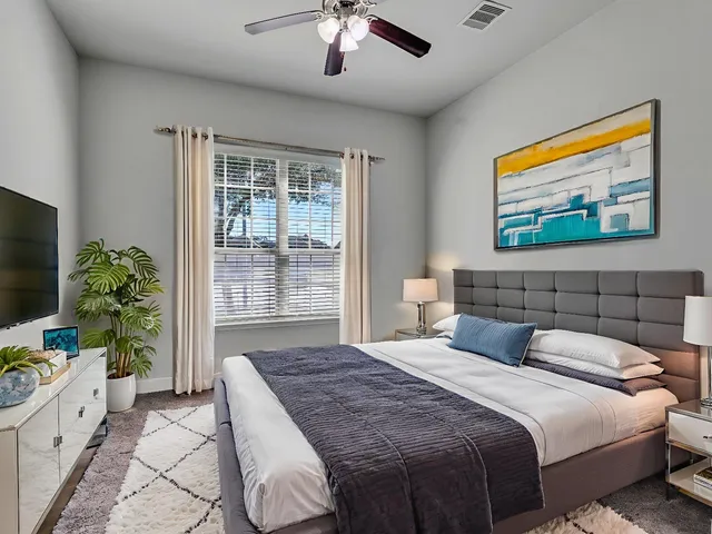 a bedroom with a large bed and a flat screen tv