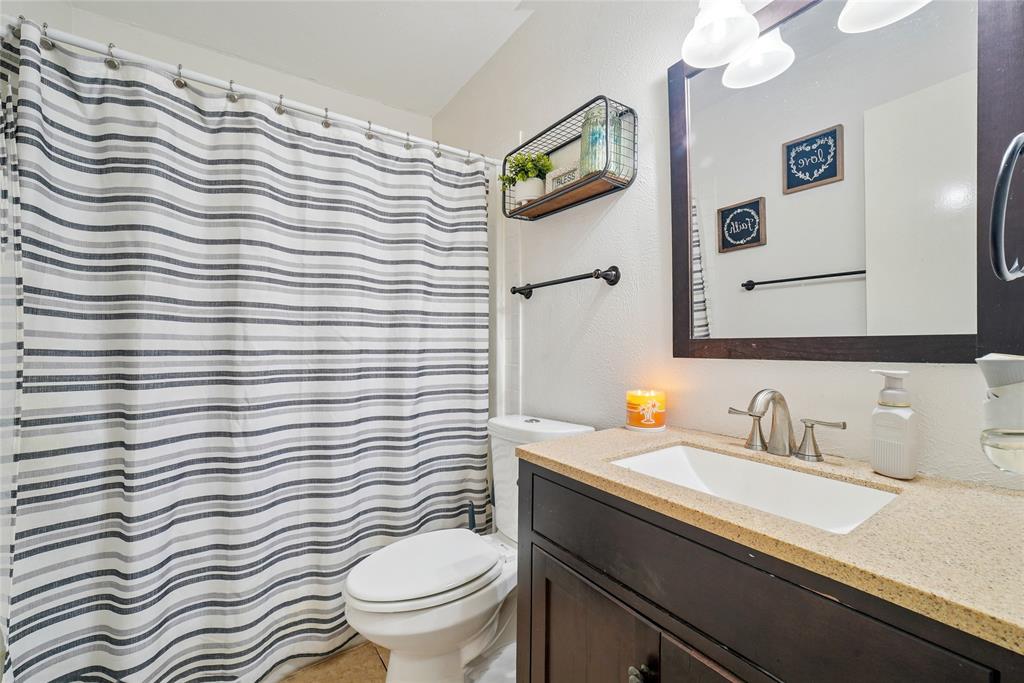 4522 Ebb Tide Drive Rowlett, TX 75088 - Photo 15 of 26 a bathroom with a sink a toilet and mirror