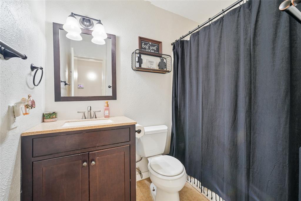 4522 Ebb Tide Drive Rowlett, TX 75088 - Photo 18 of 26 a bathroom with a toilet sink vanity and mirror