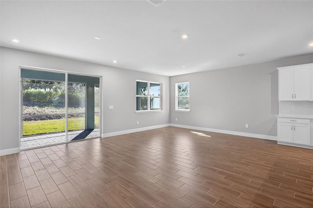 12349 49th Street East Parrish, FL 34219 - Photo 11 of 38 a view of an empty room with a window and wooden floor