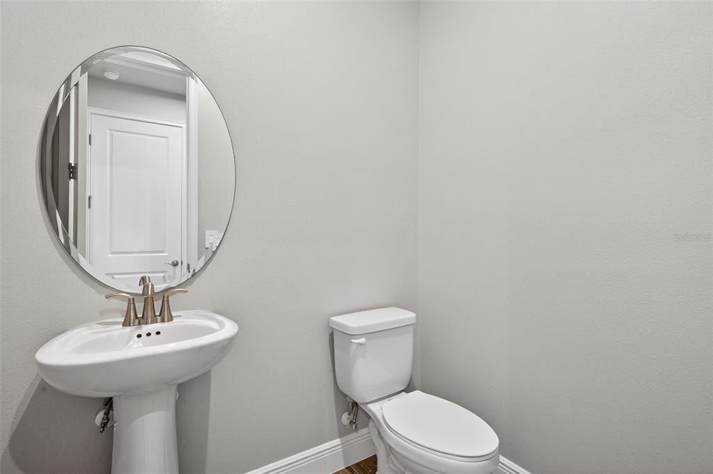 12349 49th Street East Parrish, FL 34219 - Photo 12 of 38 a bathroom with a toilet a sink and mirror