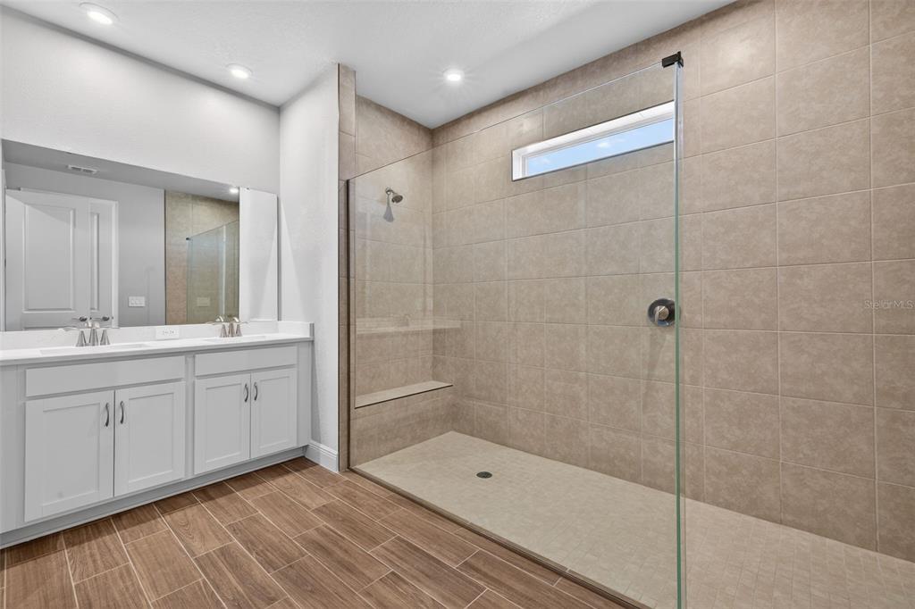 12349 49th Street East Parrish, FL 34219 - Photo 15 of 38 a bathroom with a shower sink and mirror