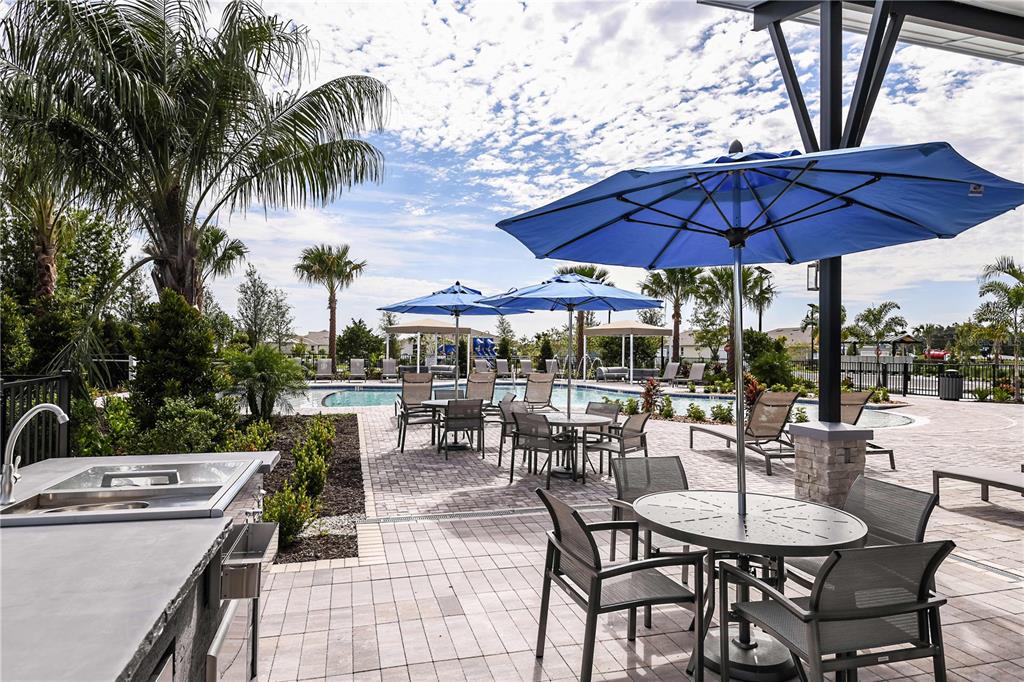12349 49th Street East Parrish, FL 34219 - Photo 36 of 38 a patio with a table and chairs under an umbrella