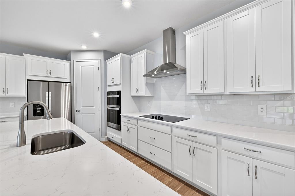 12349 49th Street East Parrish, FL 34219 - Photo 6 of 38 a kitchen with stainless steel appliances granite countertop white cabinets and a refrigerator