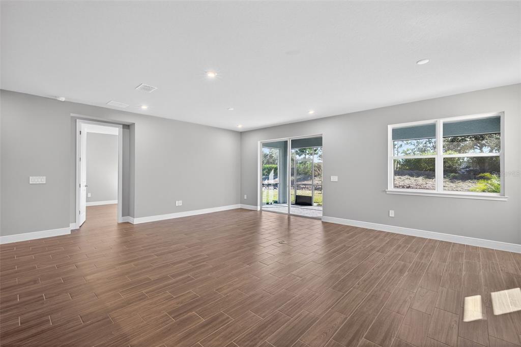 12349 49th Street East Parrish, FL 34219 - Photo 10 of 38 a view of an empty room with wooden floor and a window