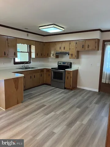 a large kitchen with stainless steel appliances granite countertop a stove and a sink