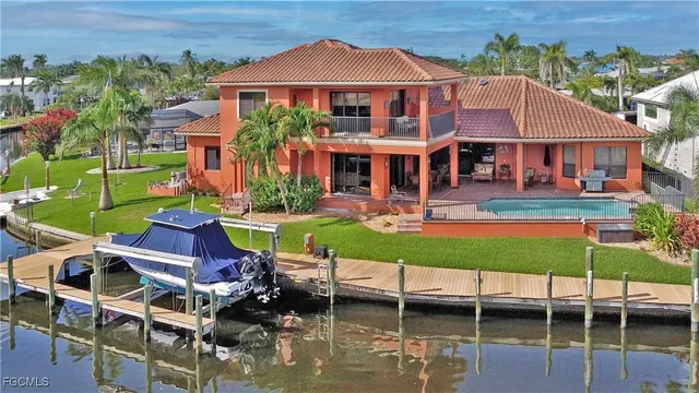 an aerial view of a house with swimming pool and a yard