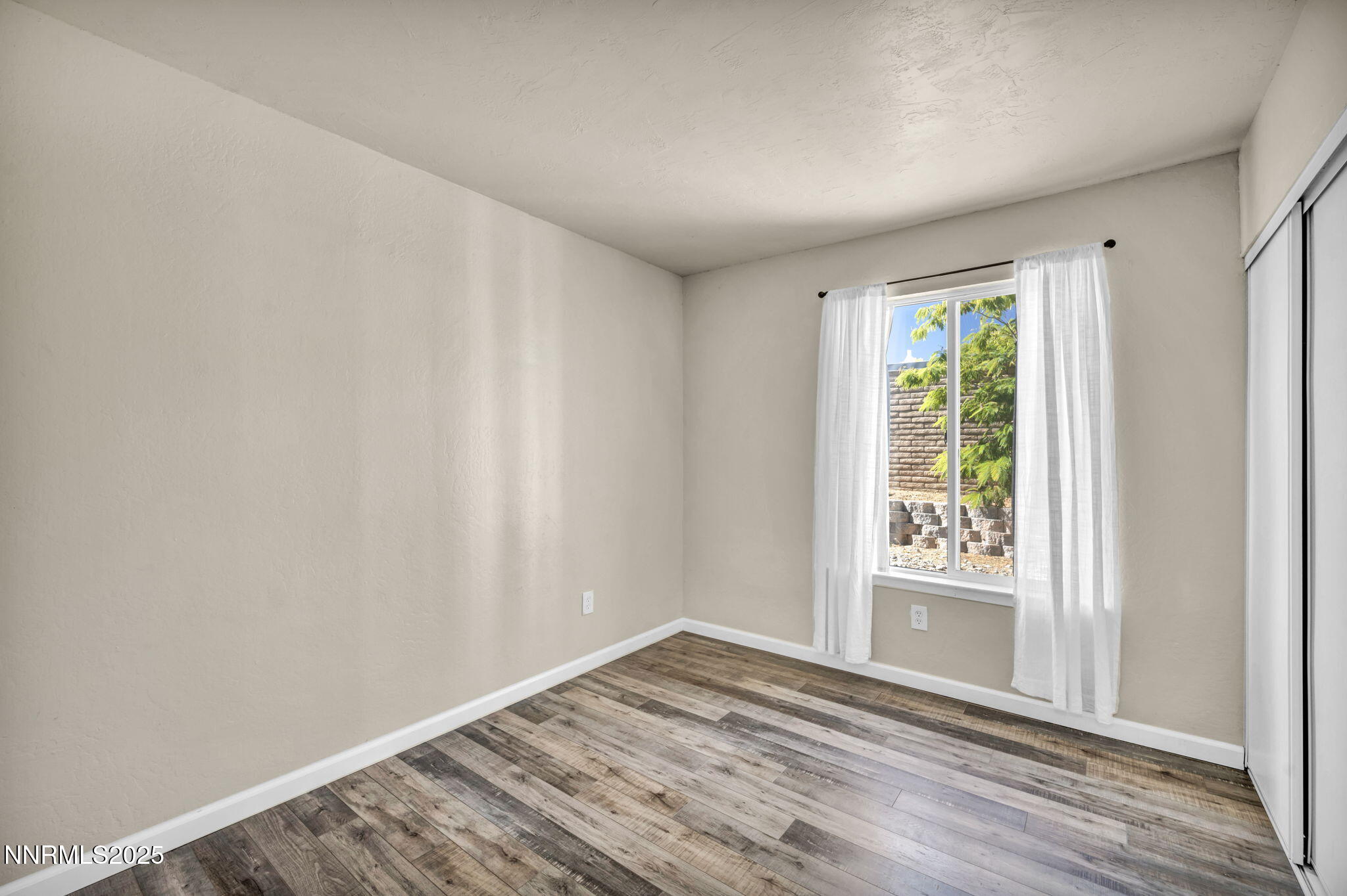 11 Castle Way Carson City, NV 89706 - Photo 24 of 34 an empty room with wooden floor and windows