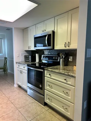 a kitchen with stainless steel appliances granite countertop a stove and a microwave