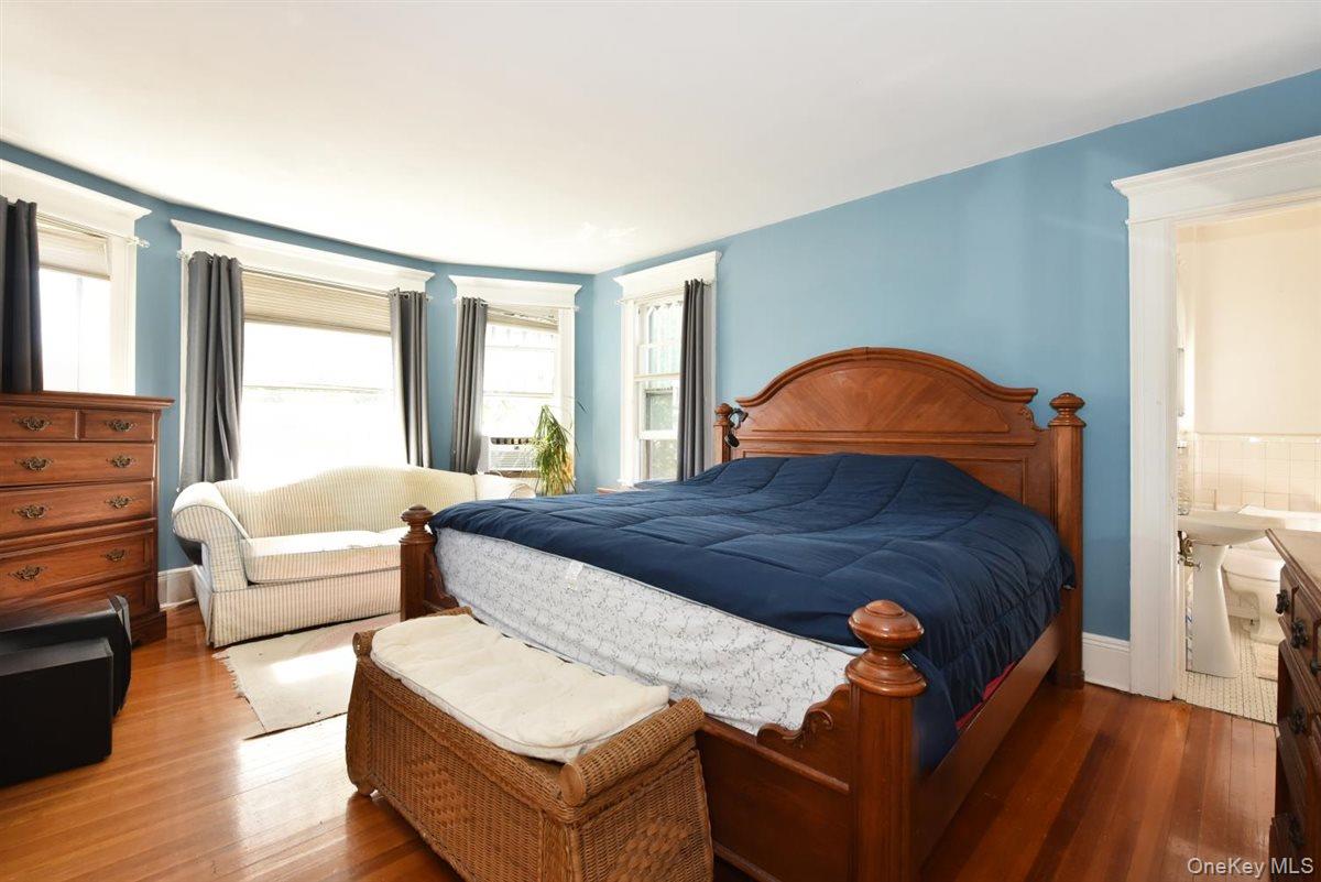 101 Wallace Street Freeport, NY 11520 - Photo 16 of 37 a bedroom with a bed and wooden floor