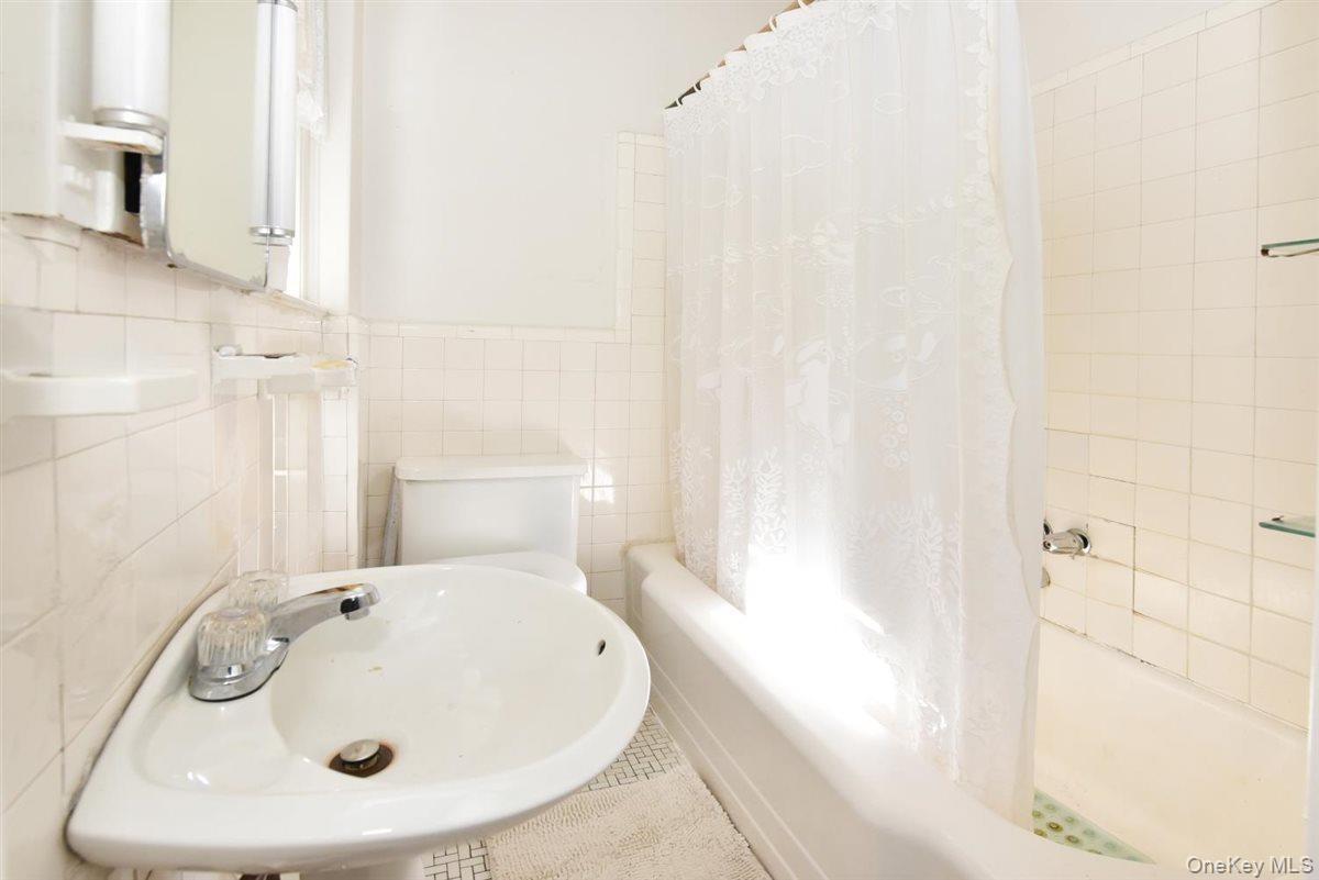 101 Wallace Street Freeport, NY 11520 - Photo 17 of 37 a bathroom with a white sink and a bathtub