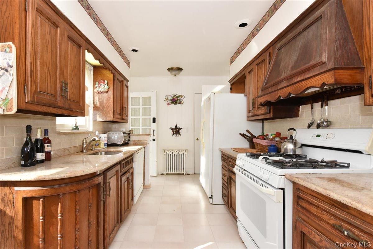 101 Wallace Street Freeport, NY 11520 - Photo 8 of 37 a kitchen with stainless steel appliances a sink stove and cabinets