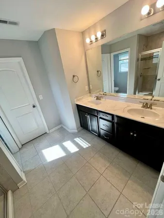 a spacious bathroom with a double vanity sink mirror and bathtub