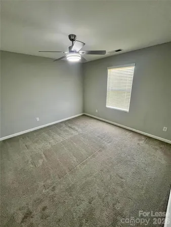 an empty room with a ceiling fan and a window